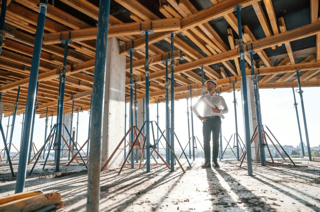 Beautiful sunlight. Walking with plan in hands. Man is working on the construction site at daytime